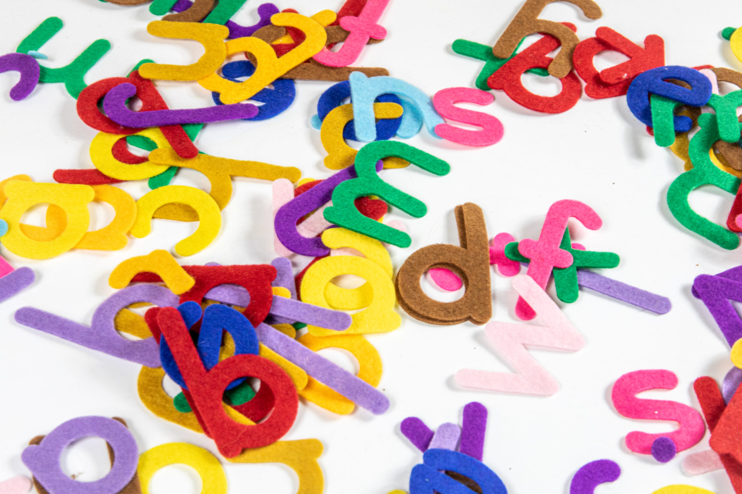 Colourful letters of the alphabet scattered on a white background