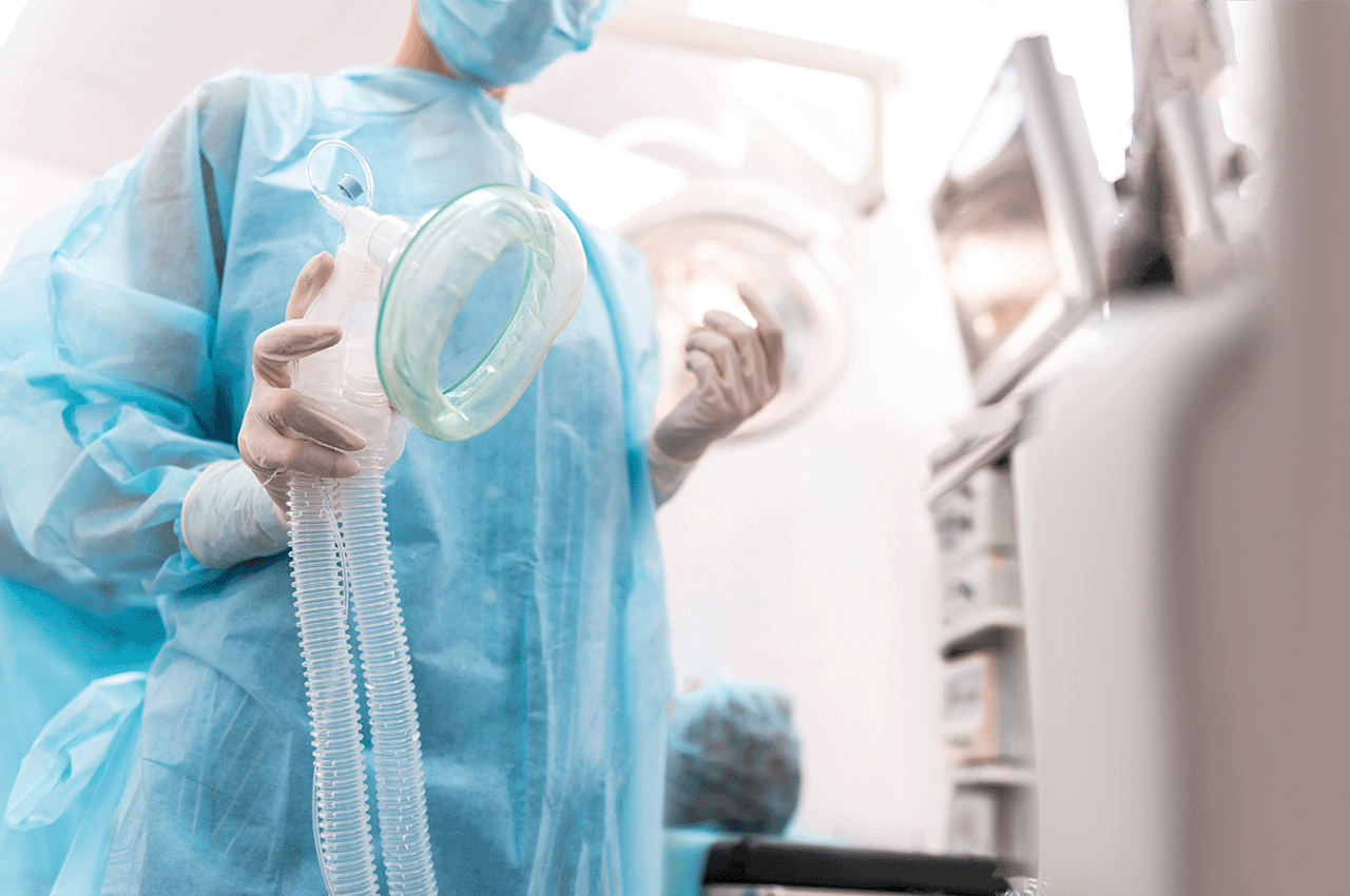 Clinician holding anesthesia mask in readiness for operation